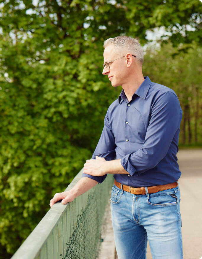 Mann am Geländer einer Brücke