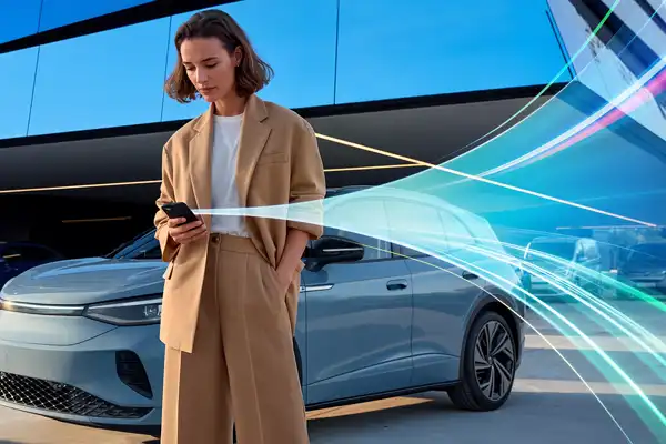 Kundin von Auto Fleet Control vor ihrem Auto mit einem Smartphone in der Hand Kundin von Auto Fleet Control vor ihrem Auto mit einem Smartphone in der Hand