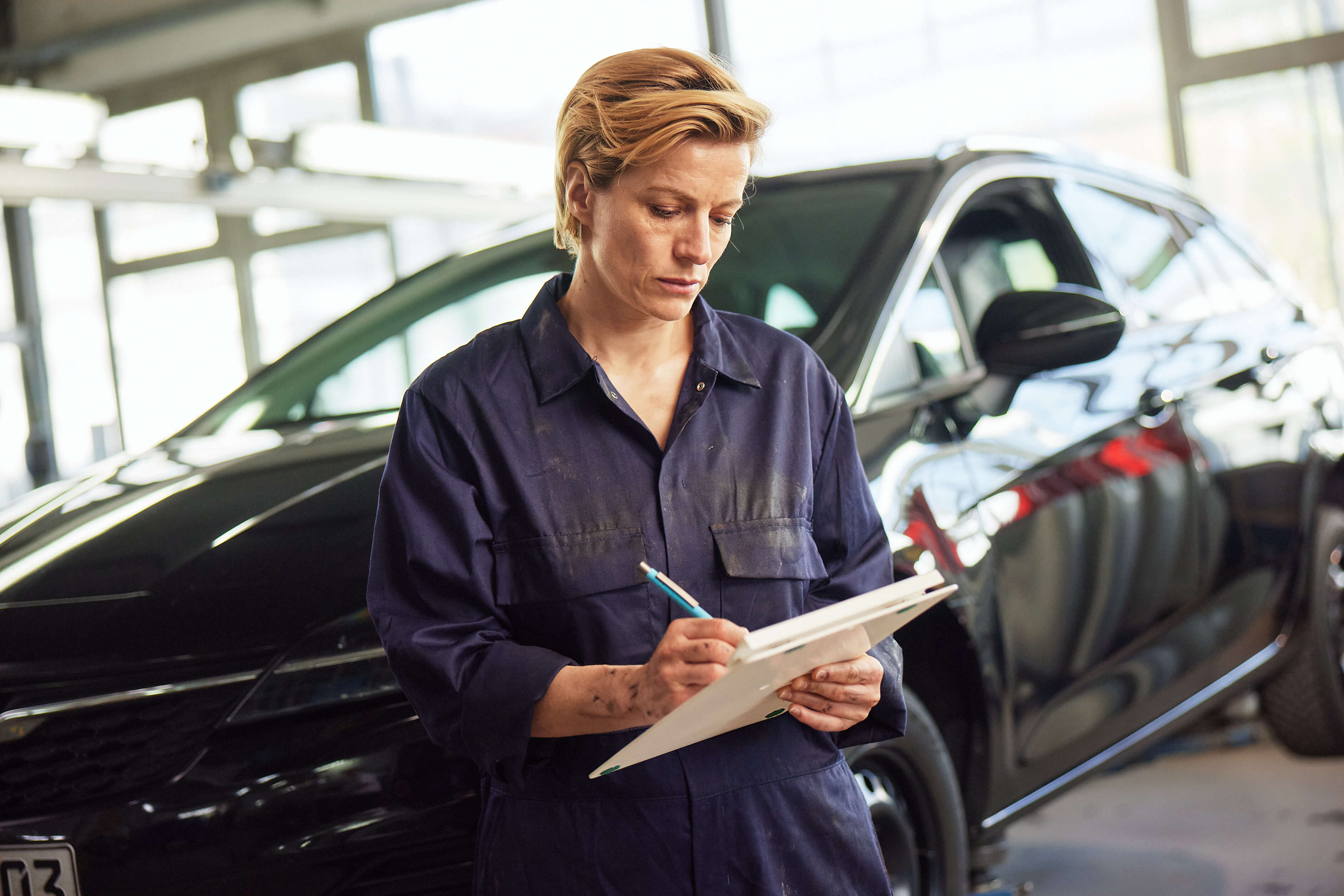 Werkstattmitarbeiterin mit Klemmbrett